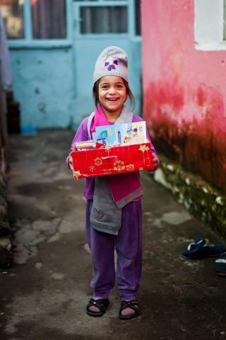 Kind mit Geschenk von Weihnachten im Schuhkarton